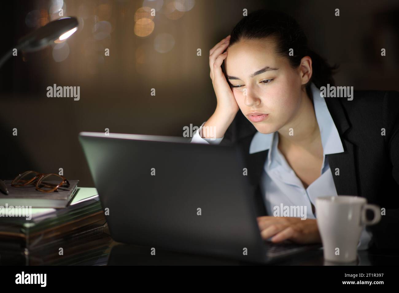 Un dirigente stanco che lavora di notte con un notebook Foto Stock