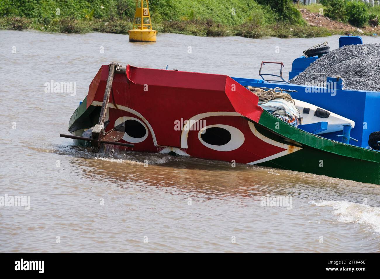 Traffico fluviale sul fiume Saigon, Vietnam. Gli occhi neri nel cerchio bianco sulla prua della barca sono la tradizionale protezione contro gli spiriti del fiume malvagio. Foto Stock