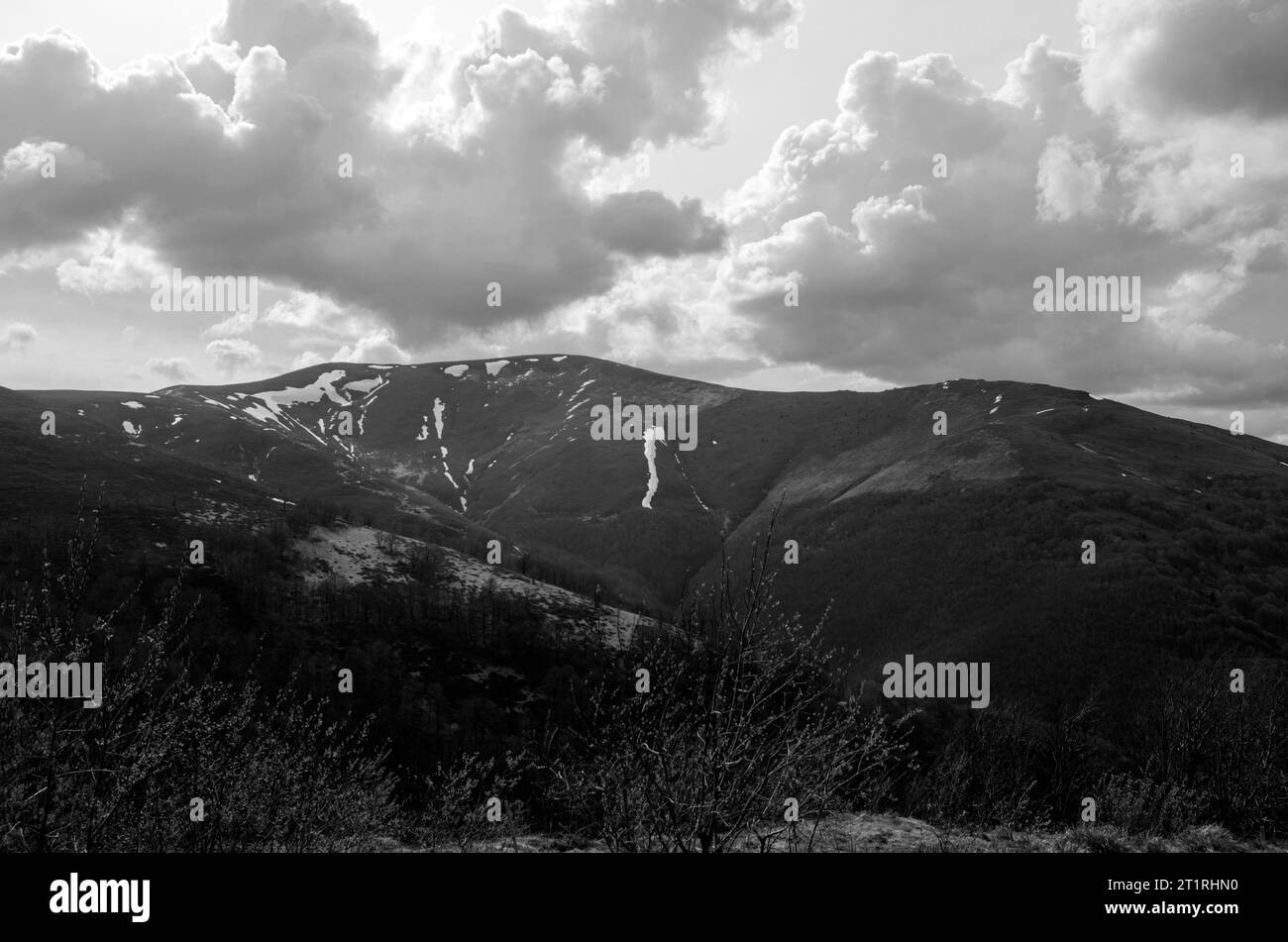 Montagne e colline sotto un cielo torbido e pesante sfondo bianco e nero Foto Stock