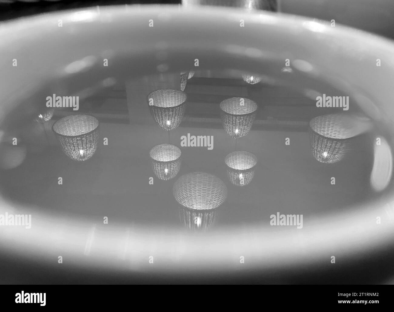 Le luci bianche e nere riflettono su una tazza di tè sullo sfondo, carta da parati astratta Foto Stock