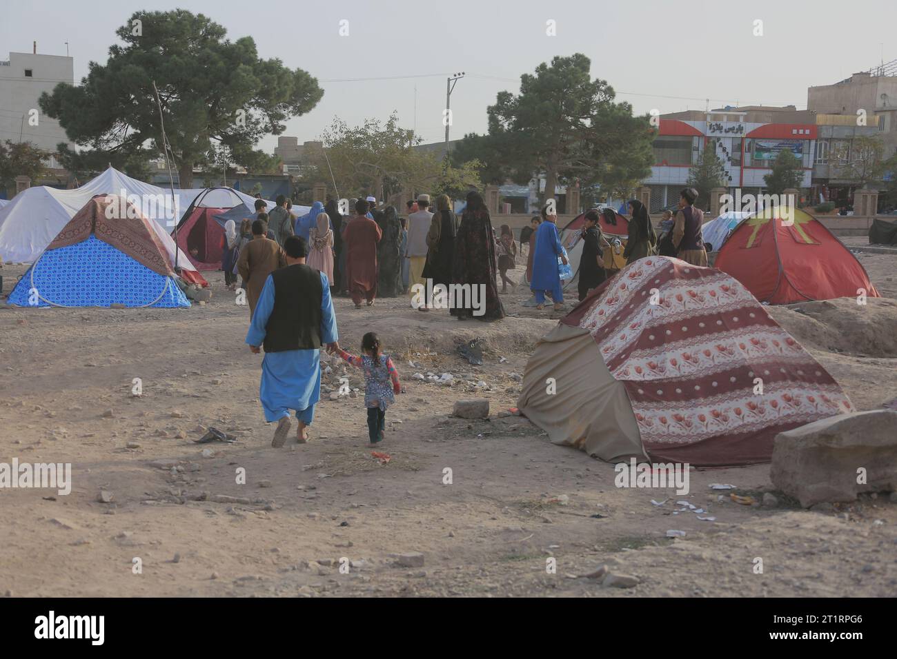 Herat, provincia afghana di Herat. 15 ottobre 2023. La gente è vista vicino alle tende sul terreno aperto per paura delle scosse nella città di Herat, nella provincia di Herat dell'Afghanistan occidentale, 15 ottobre 2023. Due sono morti e 125 feriti sono stati portati in ospedale a seguito di tremori nella provincia di Herat nell'Afghanistan occidentale domenica, ha detto Farhad Afzali, un medico dell'ospedale di Herat. Credito: Saifurahman Safi/Xinhua/Alamy Live News Foto Stock