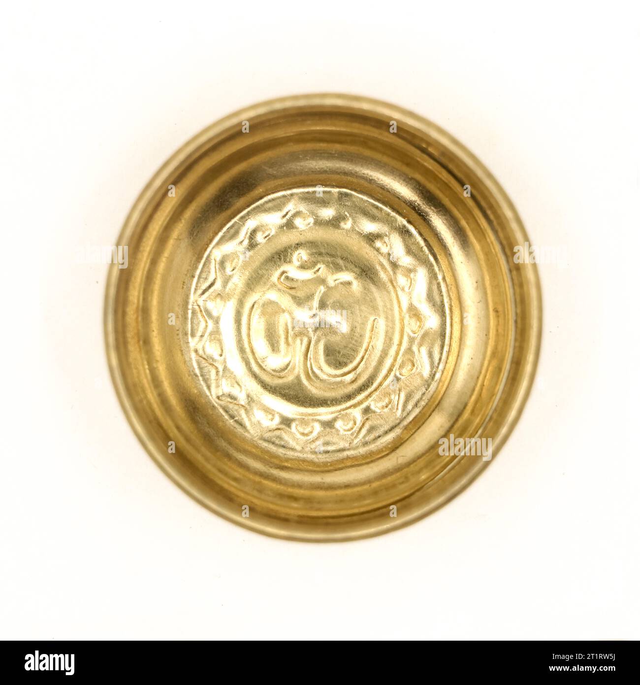 una tradizionale ciotola di preghiera dorata con un antico simbolo indù om scolpito all'interno del piatto isolato su uno sfondo bianco Foto Stock