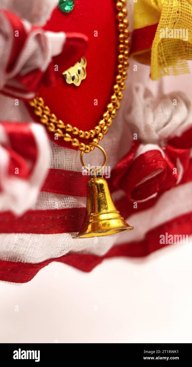 primo piano della decorazione natalizia con campana dorata e tessuto a righe rosse e bianche per festeggiare Foto Stock