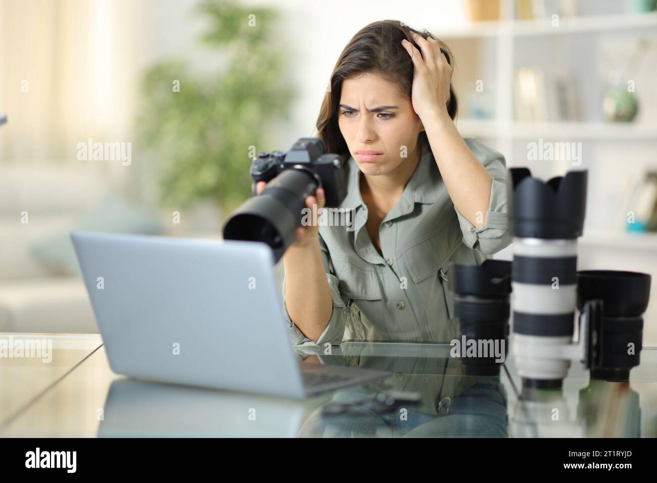 Fotografo preoccupato a casa che controlla i risultati negativi sulla fotocamera Foto Stock