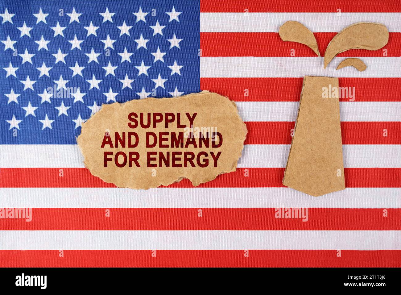 Sulla bandiera degli Stati Uniti c'è una piattaforma petrolifera tagliata fuori dal cartone e un cartello con l'iscrizione - domanda e offerta di energia. Foto Stock
