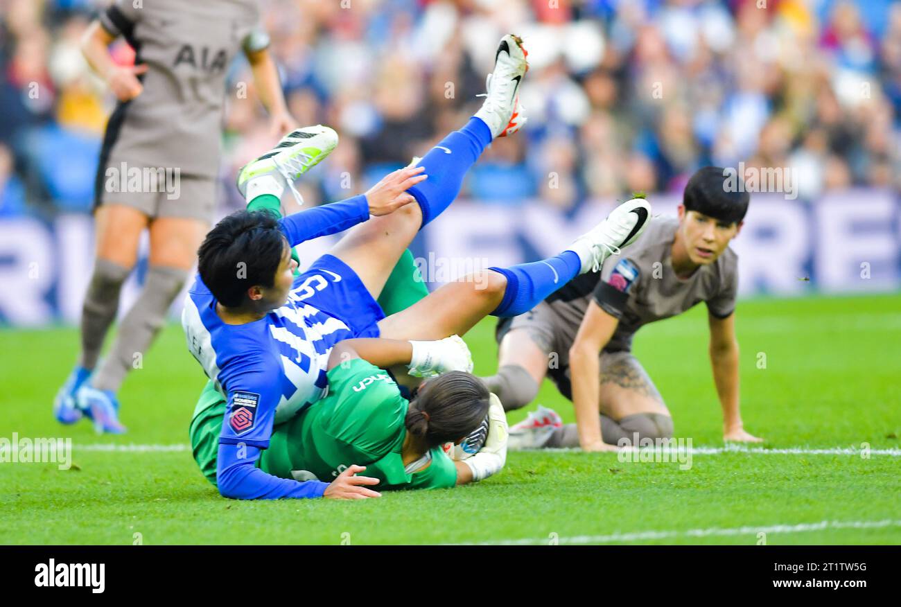 Brighton Regno Unito 15 ottobre 2023 - Geummin Lee di Brighton cade sul portiere Becky Spencer del Tottenham durante la partita di calcio femminile della Super League di Barclays tra Brighton e Hove Albion e Tottenham Hotspur all'American Express Stadium (solo per uso editoriale) : Credit Simon Dack /TPI/ Alamy Live News Foto Stock