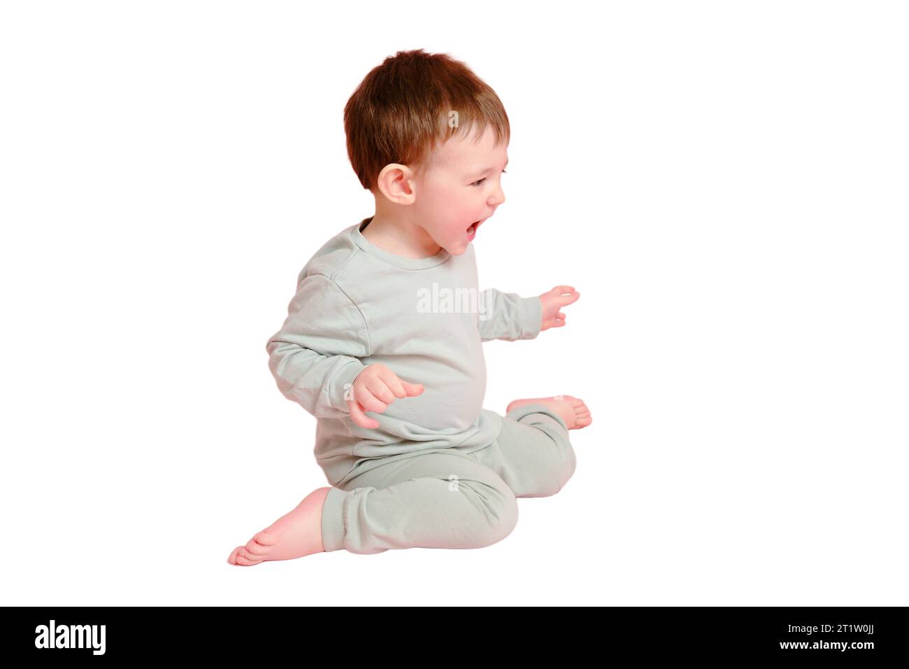 Allegro bimbo piccolo in studio, spazio copia, isolato su sfondo bianco. Bambino emotivo con un sorriso sul viso, a tutta altezza, isolato su b bianco Foto Stock