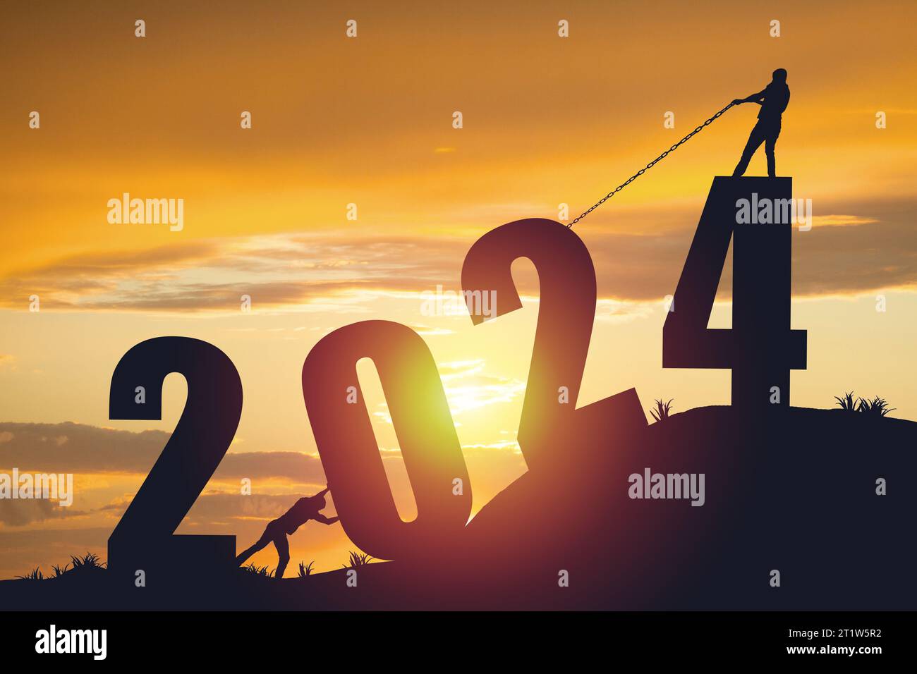 Silhouette da uomo che spinge e e tira l'anno 2024 su uno sfondo dorato all'alba Foto Stock