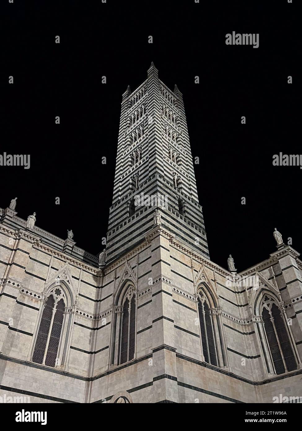 Di notte si può ammirare il campanile del Duomo di Siena Foto Stock