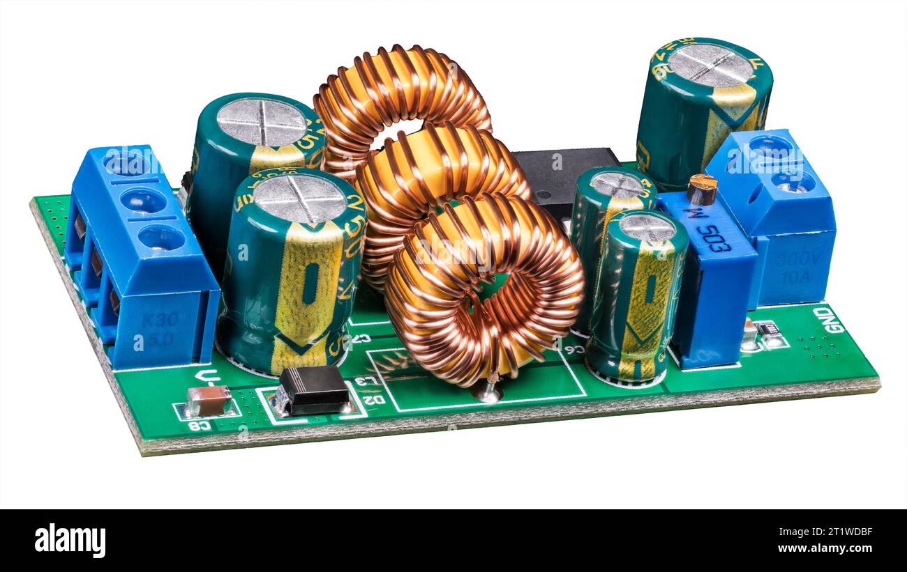 Componenti elettronici sulla scheda a circuiti stampati del convertitore di alimentazione. Primo piano di bobine con nucleo di ferrite toroidale, condensatori elettrolitici o trimmer di resistenze. Foto Stock
