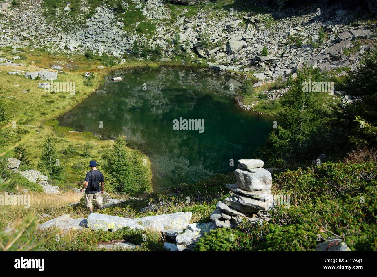 Wanderer an idylischem Bergsee im wilden und abgelegenen Val Marcri im Tessin Foto Stock