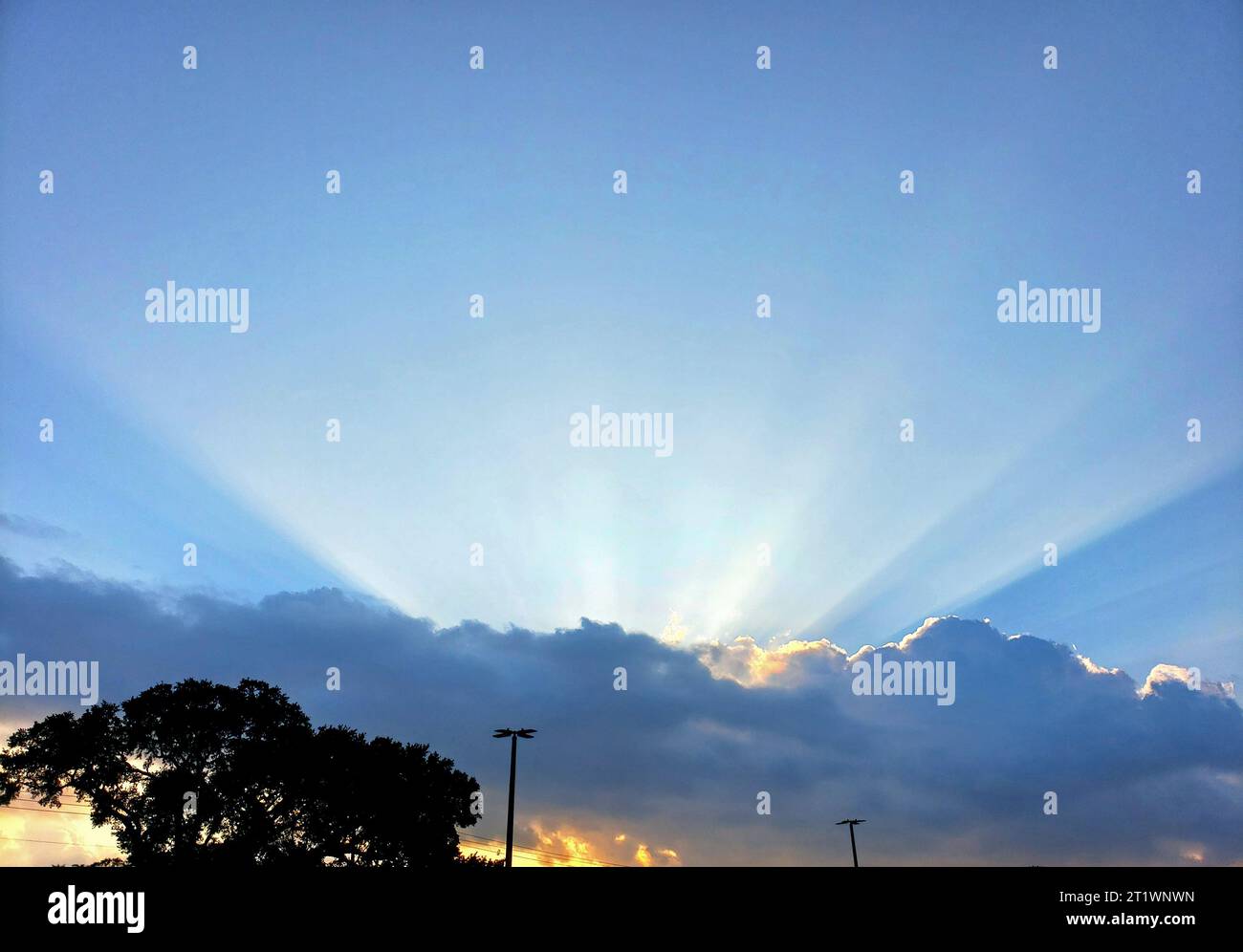 Le nuvole blu del cielo creano un'esplosione di sole Foto Stock
