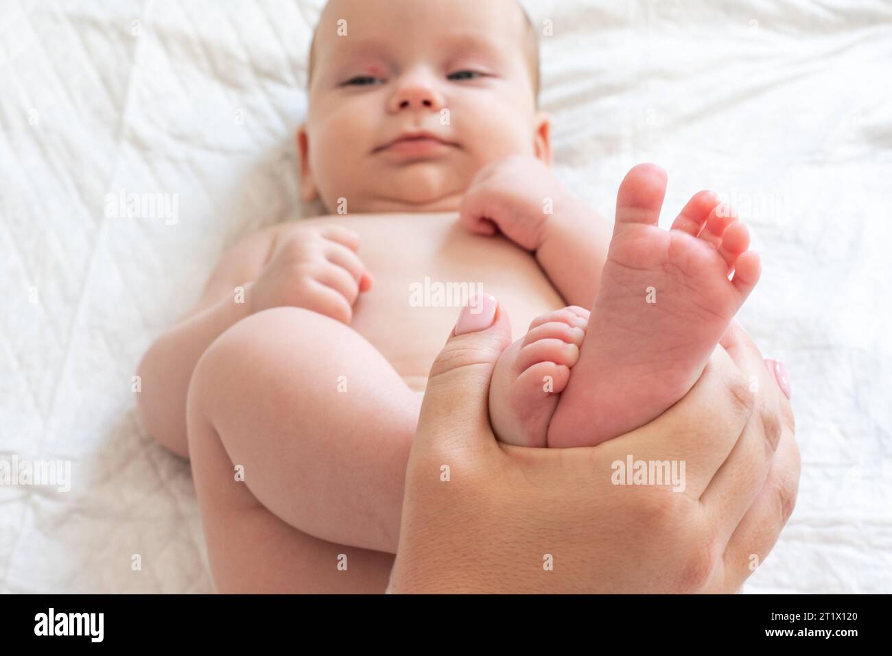 Il tempo di gioco della mamma con i piccoli piedi del bambino. Concetto di momenti materni cari Foto Stock