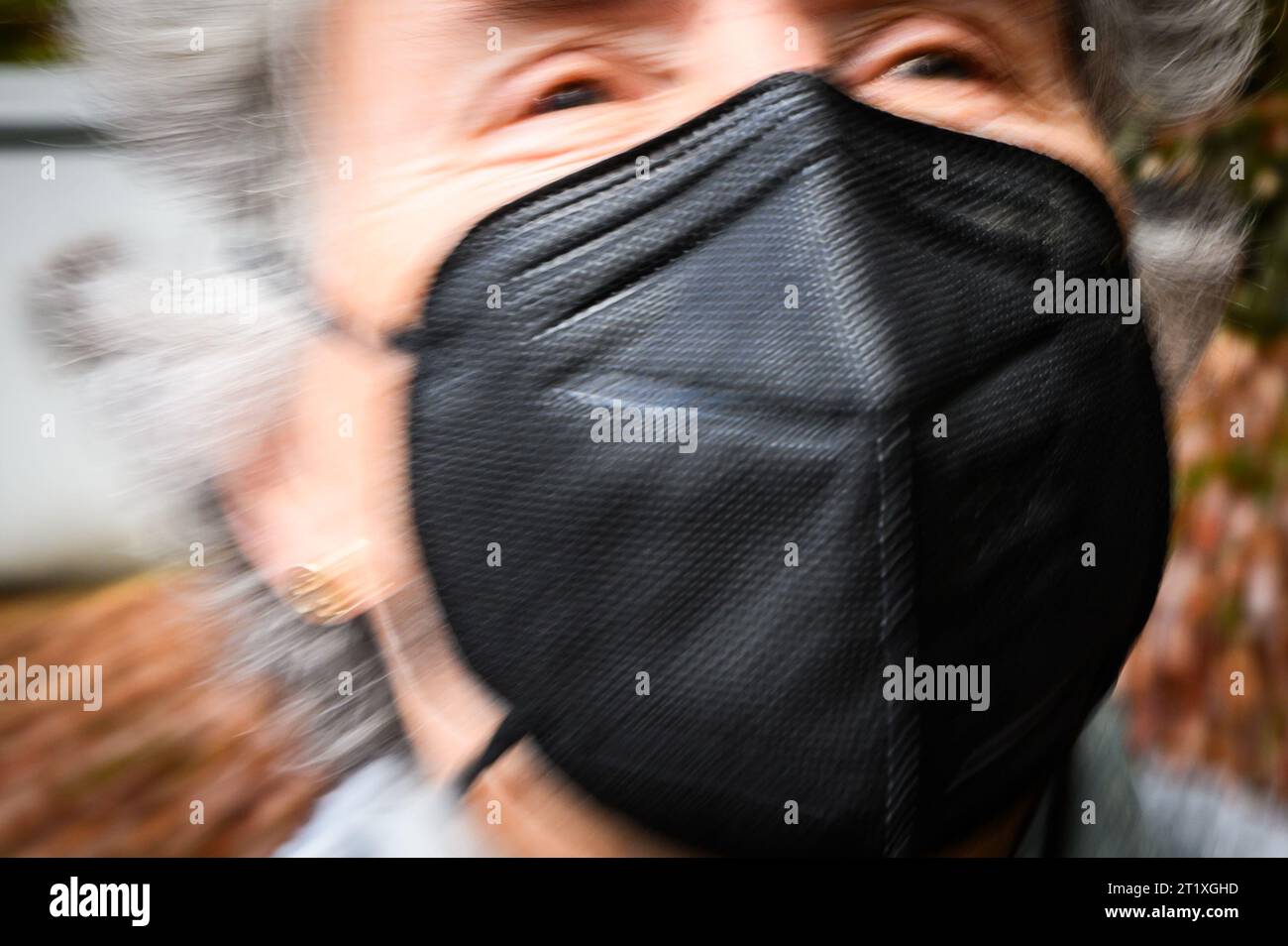 La donna indossa una maschera facciale N95 del tipo in uso comune a causa dei tentativi di controllare la diffusione della COVID-19. Foto Stock