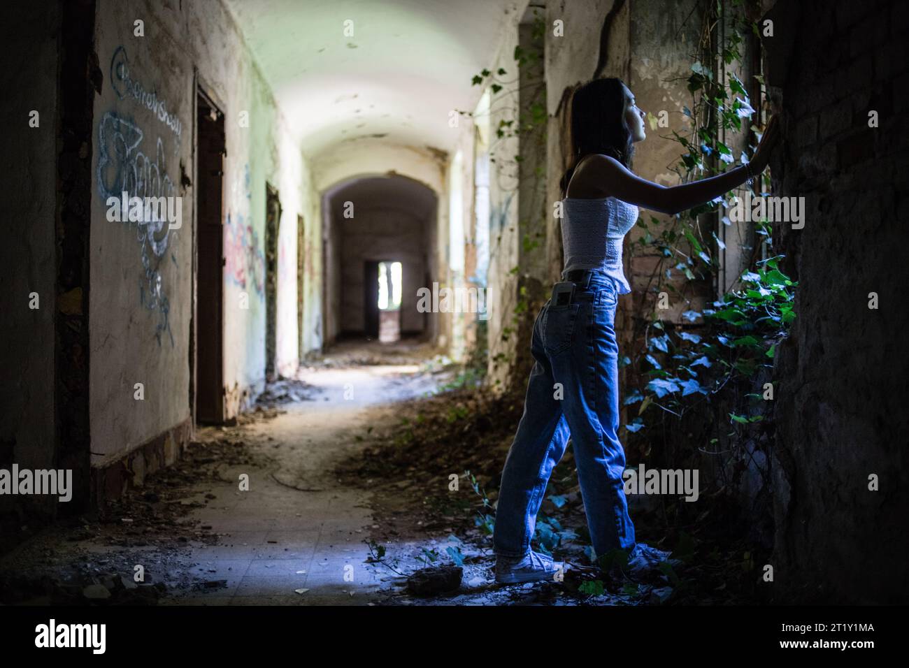 Un modello femminile si pone all'interno delle rovine di una base militare dell'epoca sovietica a Szombatheley, in Ungheria. Foto Stock