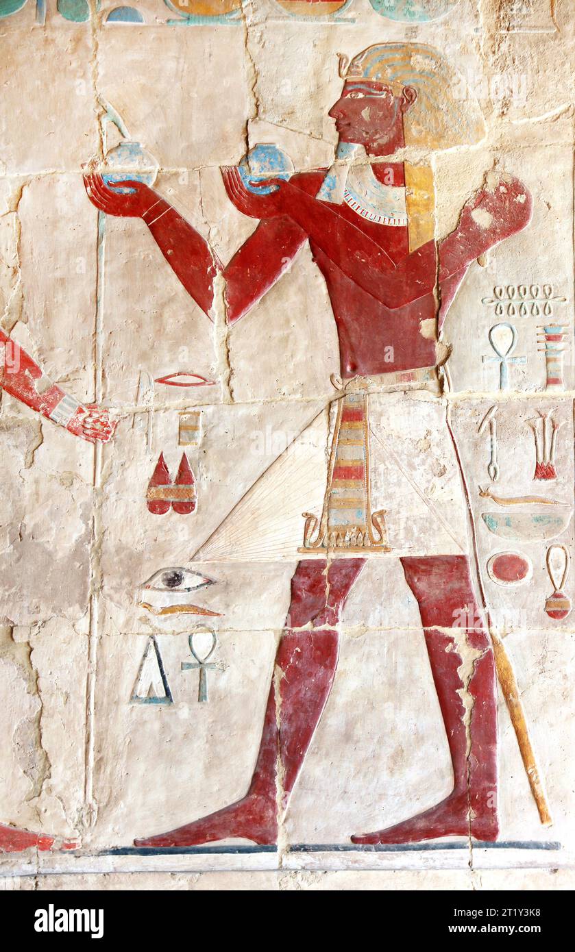 Antico dipinto murale colorato all'interno del tempio di Hatshepsut nella Valle dei Re, Luxor, Egitto. Figura del faraone che fa offerte rituali, wal Foto Stock