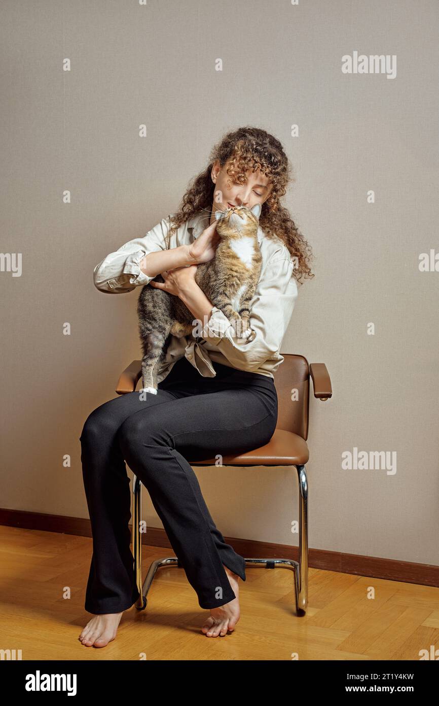 Giovane donna scalza che gioca con gatto Foto Stock
