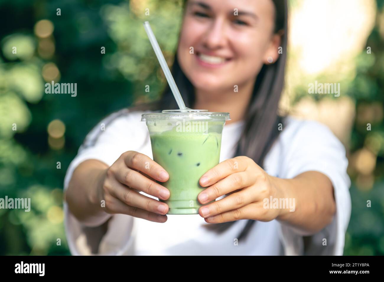 Tè verde freddo con latte in mano. Foto Stock