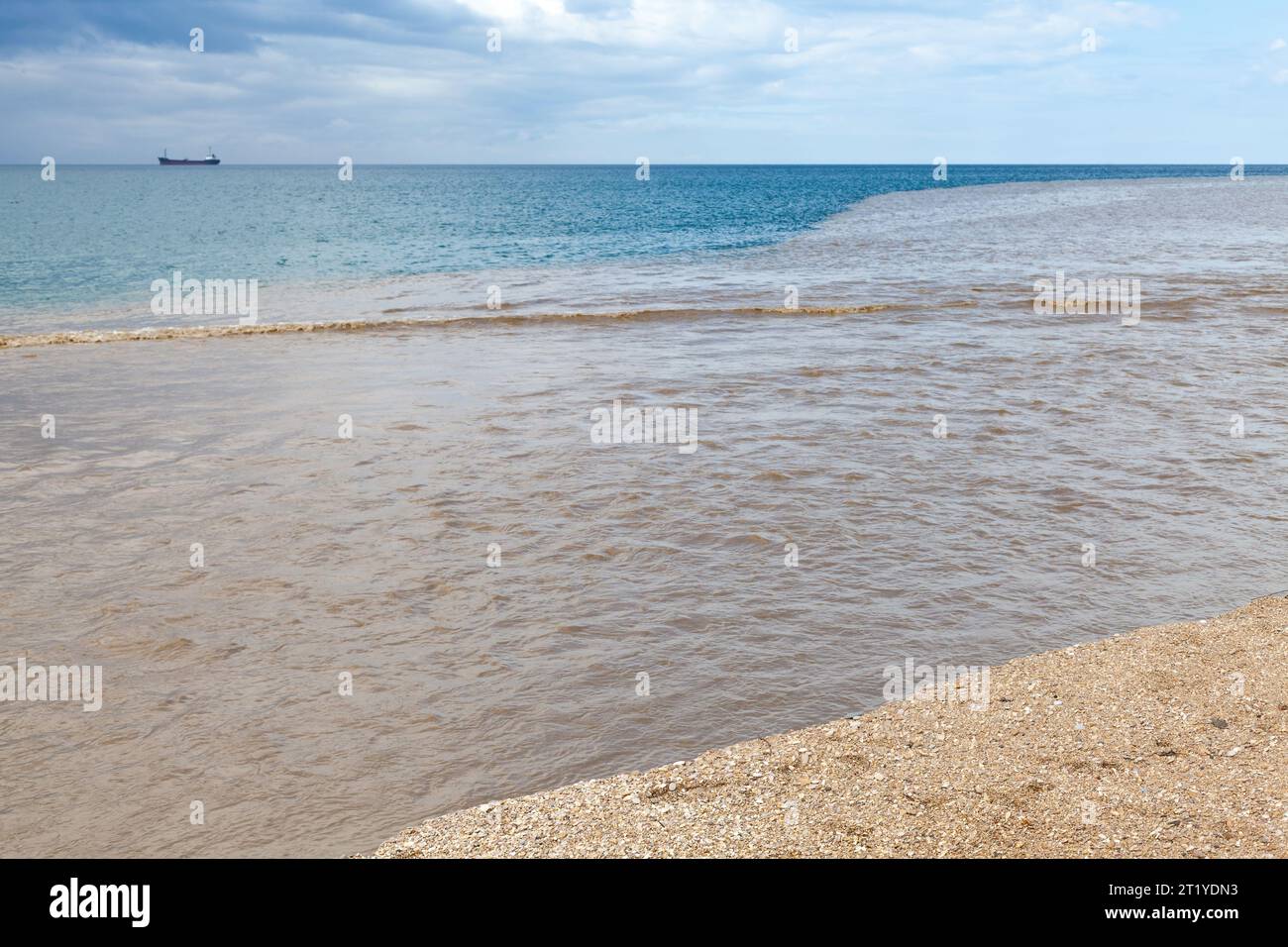 Paesaggio costiero estivo con acqua di fiume fangosa che si mescola con acqua di mare blu. Crimea, costa del Mar Nero Foto Stock