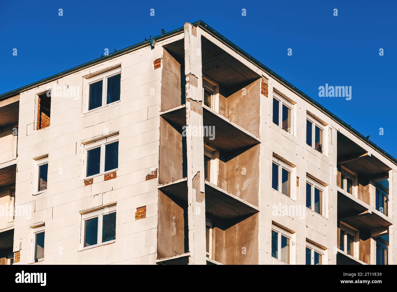 Edificio condominiale non finito con pannello isolante in espanso di polistirene rigido incollato alla parete esterna, vista angolare bassa Foto Stock