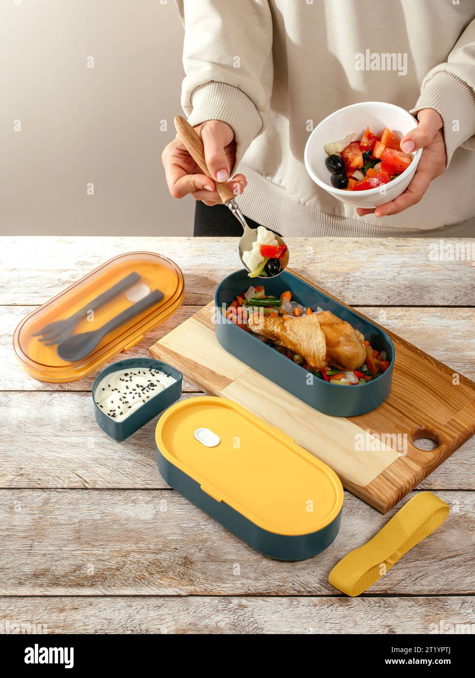 Donna che prepara cibo per suo figlio a tavola in cucina, primo piano. H Foto Stock