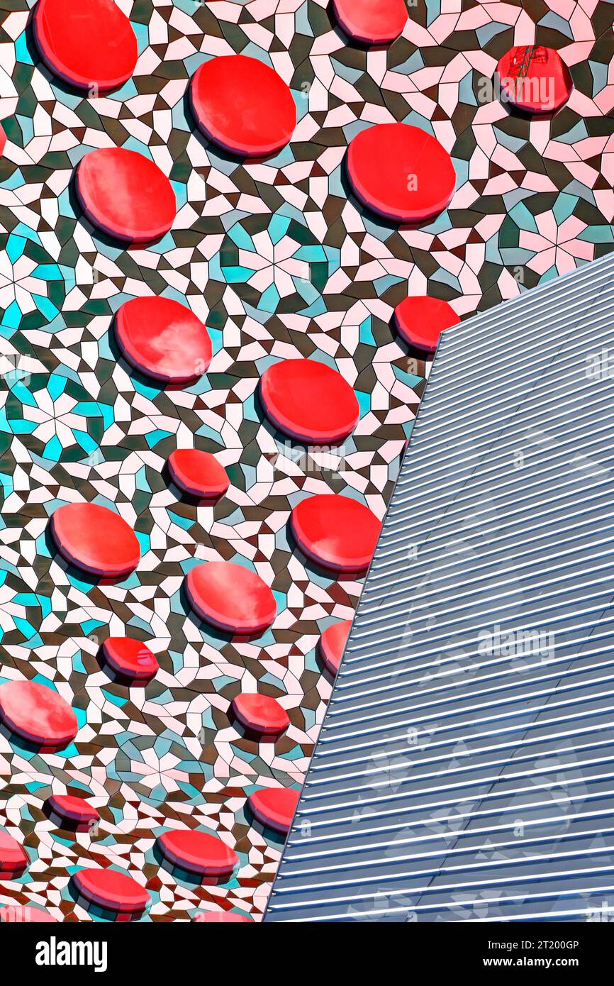 Primo piano astratto del rivestimento architettonico dell'edificio di colore rosso manipolato su pannelli rialzati circolari sfondo a scacchi con griglie Inghilterra Regno Unito Foto Stock