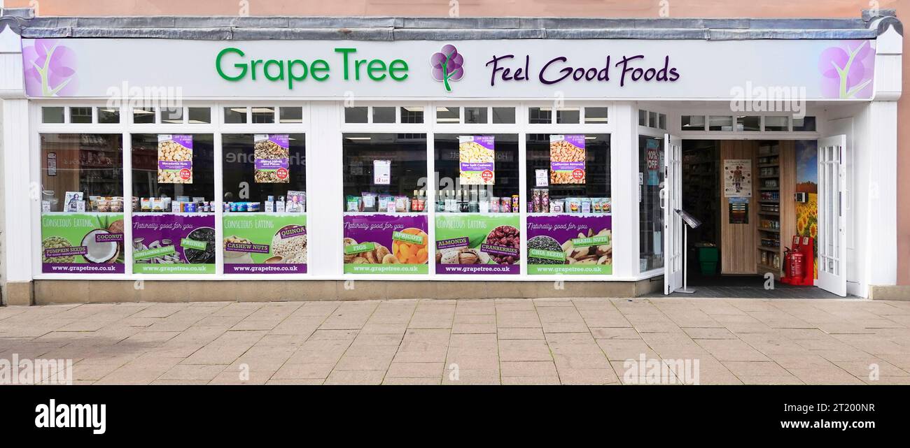 Grape Tree Feel Good Foods cartello sulla plancia sopra le vetrine del negozio e l'ingresso dall'ampio marciapiede di Bury St Edmunds Suffolk East Anglia Inghilterra Regno Unito Foto Stock