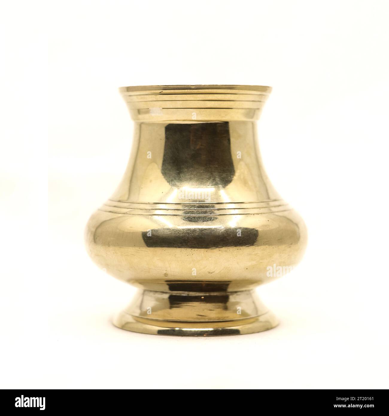 un recipiente di ottone indiano dorato pulito utilizzato come vaso d'acqua per i rituali tradizionali durante le feste religiose indù isolato su sfondo bianco Foto Stock