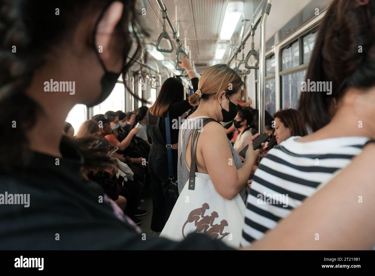 Manila, Filippine: Pendolari filippini all'interno di una cabina su un treno LRT in movimento linea 1. All'interno del vano Light Rail Transit 1. Mezzi pubblici. Foto Stock