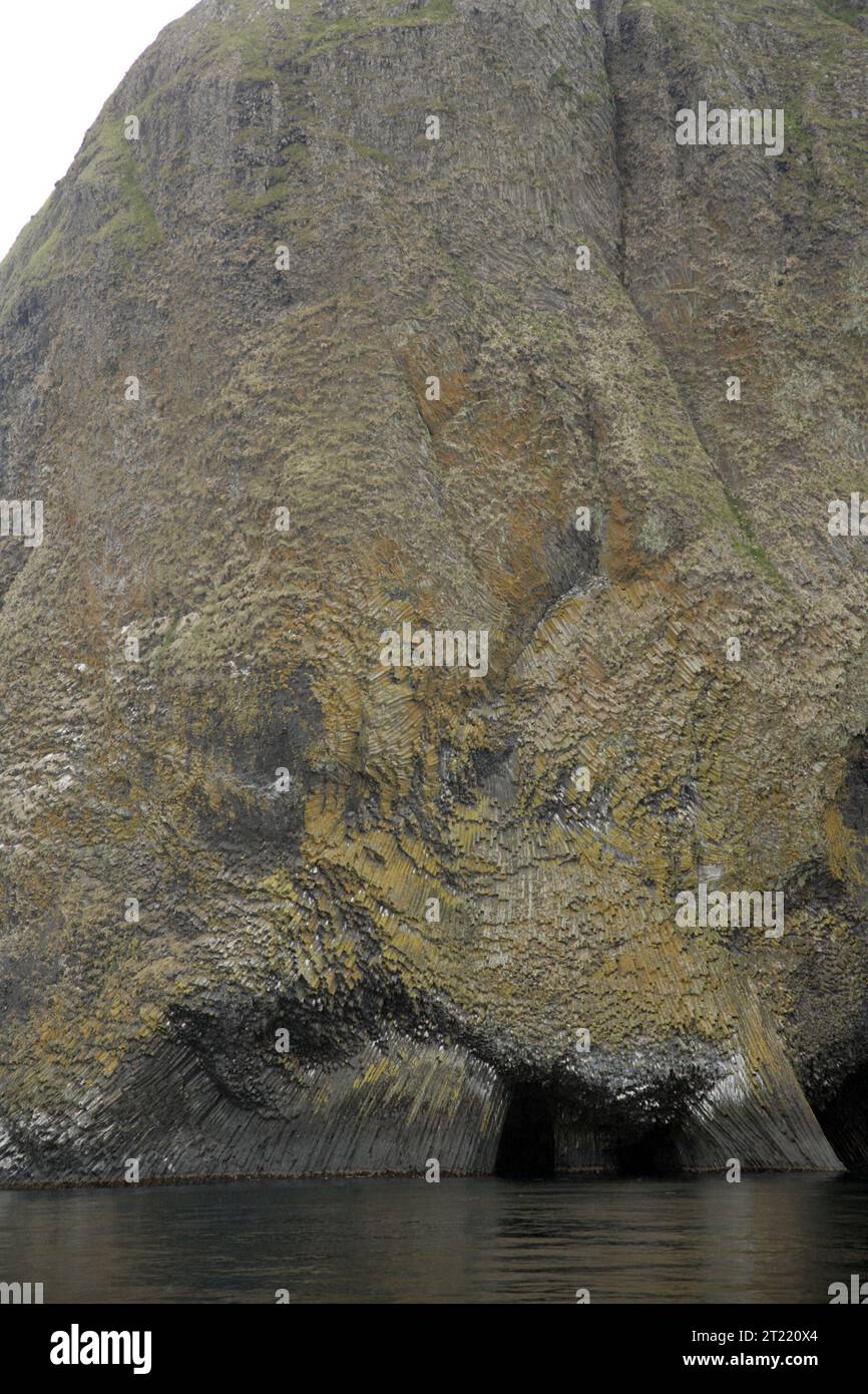 Una vista delle formazioni di basalto colonnare sull'isola di Akun all'interno dell'Alaska Maritime National Wildlife Refuge. Queste caratteristiche geologiche fanno parte dell'aspro ambiente costiero delle Isole Aleutine, note per il loro suggestivo paesaggio e la storia vulcanica. Foto Stock
