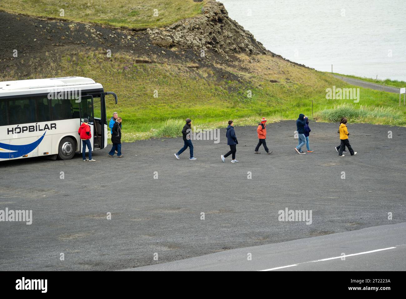 Myvatn, Islanda - 4 luglio 2023: L'autobus del tour lascia le persone per fare un'escursione sul sentiero dei pseudo crateri Skutustadagrig, sul lago Myvatn. Interessante forma geologica Foto Stock