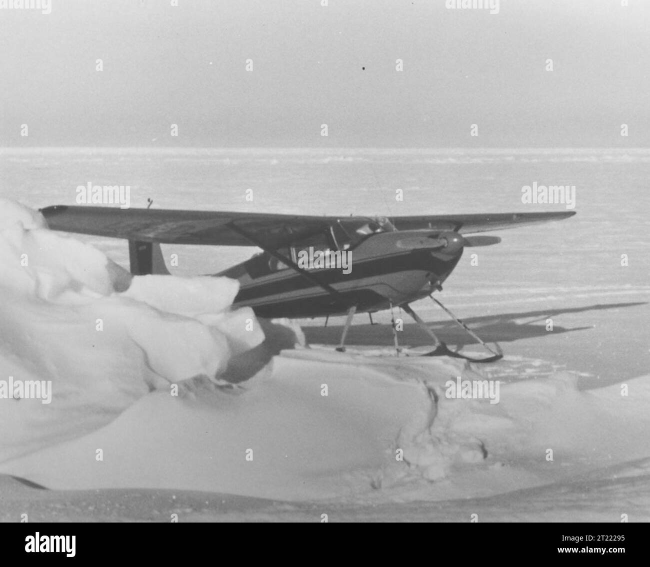 Un piccolo aereo dotato di sci, pronto per il decollo da una pista innevata dell'Alaska. L'aeromobile è progettato per le condizioni invernali e per le piste di atterraggio remote. Oggetto: Aerei, Alaska, collezione Jim King, trasporti. Foto Stock