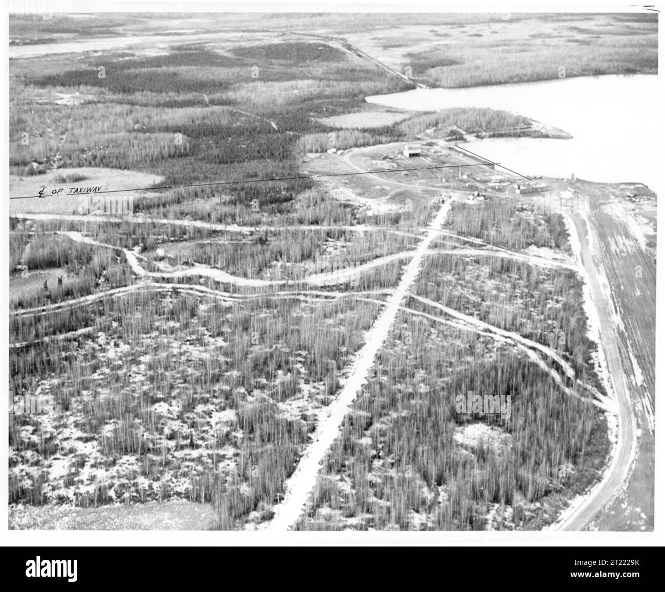 Vista aerea storica del lago Hood, di Anchorage, Alaska, con strutture per aerei, piste, e il paesaggio naturale circostante. Foto Stock