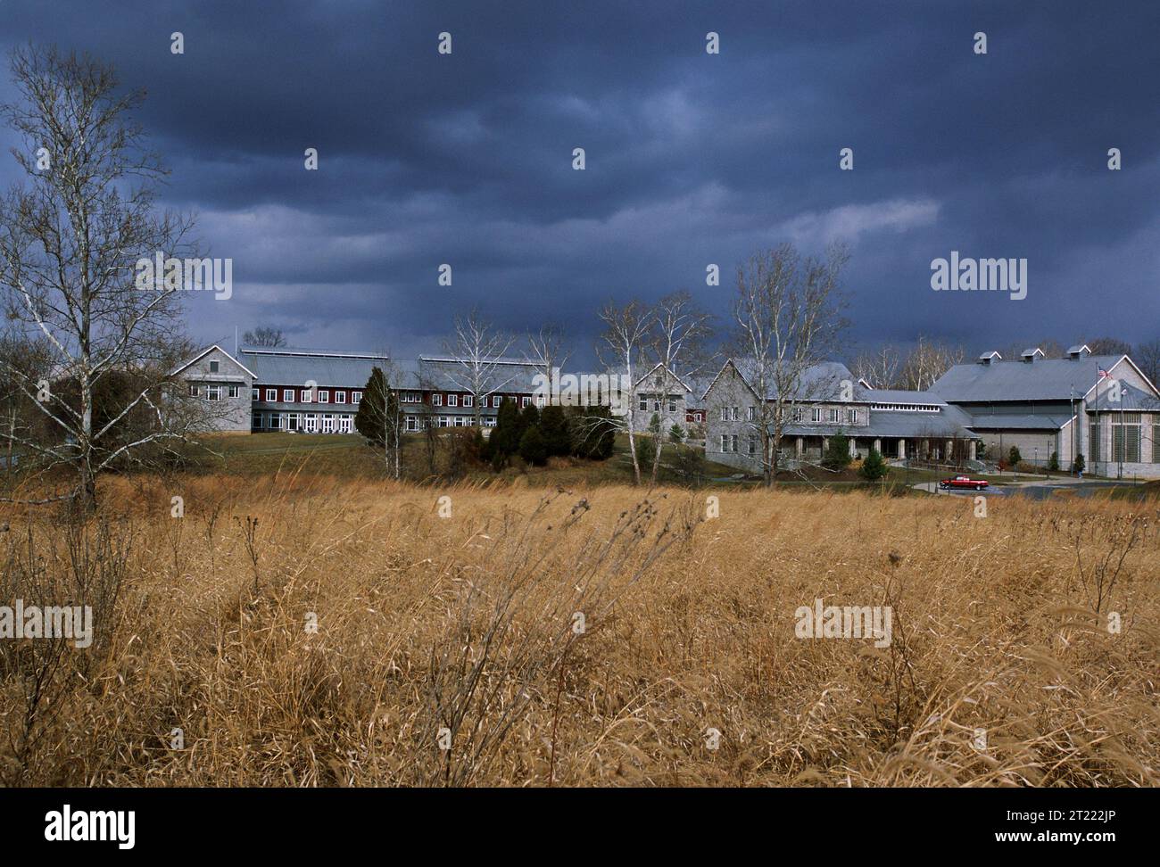 Vista distante dell'edificio d'ingresso presso il National Conservation Training Center, circondato da erba secca e campo aperto. Foto Stock