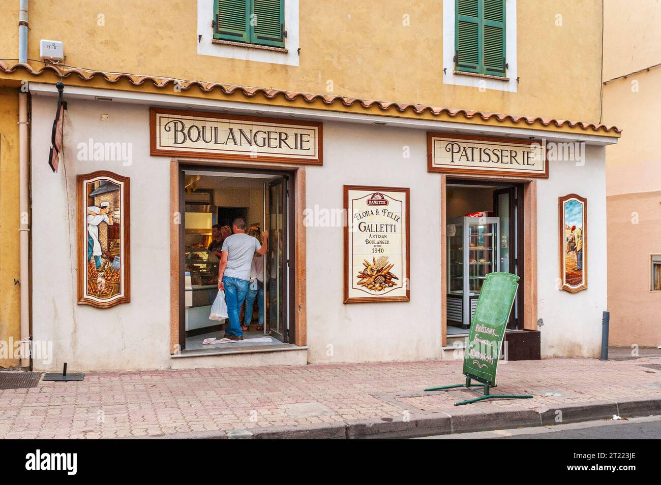 Esterno della Boulangerie con i clienti visibili all'interno attraverso la porta aperta e i cartelli decorativi della Boulangerie e dei panettieri all'esterno dell'edificio Foto Stock