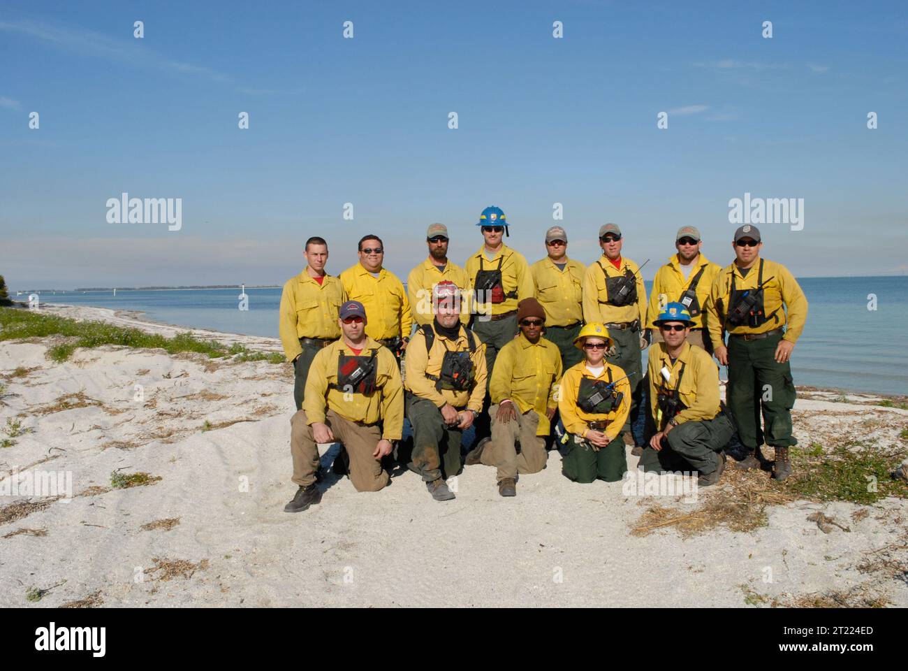 La squadra dei vigili del fuoco posa per un colpo di gruppo all'Egmont Key National Wildlife Refuge, Florida. L'equipaggio è coinvolto nella gestione degli incendi, un'attività essenziale per mantenere la salute degli habitat e controllare gli incendi che possono avere un impatto sugli ecosistemi e sulla fauna selvatica. La gestione degli incendi contribuisce a ridurre i rischi e a migliorare le condizioni dell'habitat. Foto Stock