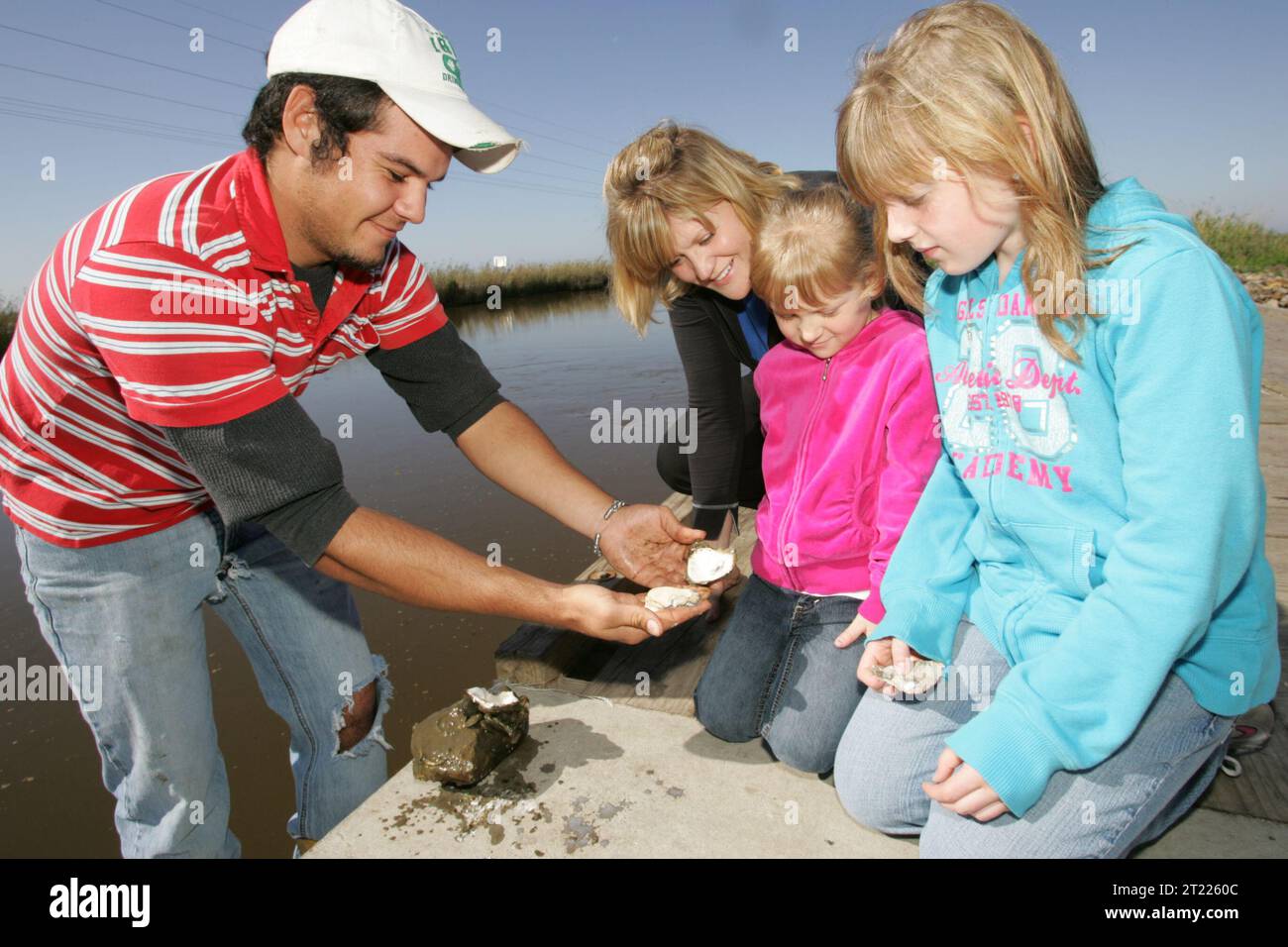 La famiglia osserva un'ostrica scottata. Soggetti: Rifugi faunistici; collegamento delle persone con la natura; bambini. Località: Louisiana. Fish and Wildlife Service Site: RISERVA NATURALE NAZIONALE SABINE. . 1998 - 2011. Foto Stock