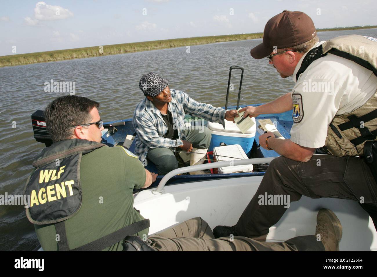 Ufficiali del Bayou Sauvage Refuge che lavorano con gli ufficiali della Louisiana Wildlife per pattugliare, proteggendo le acque. Soggetti: Ambienti acquatici; adulti; nautica; barche; ambienti costieri; gestione delle zone costiere; emblemi; ambienti (naturali); guardiani di caccia; forze dell'ordine; gestione; ambienti marini; partenariati; accesso pubblico; attività ricreative; siti ricreativi; Recrea. Località: Louisiana. Fish and Wildlife Service Site: RISERVA NATURALE NAZIONALE BAYOU SAUVAGE. Foto Stock