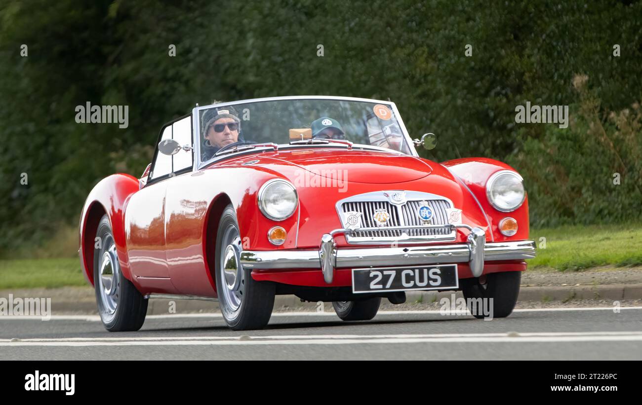 Bicester, Oxon., UK - 8 ottobre 2023: 1961 Red MG Una classica auto sportiva che guida su una strada di campagna inglese. Foto Stock