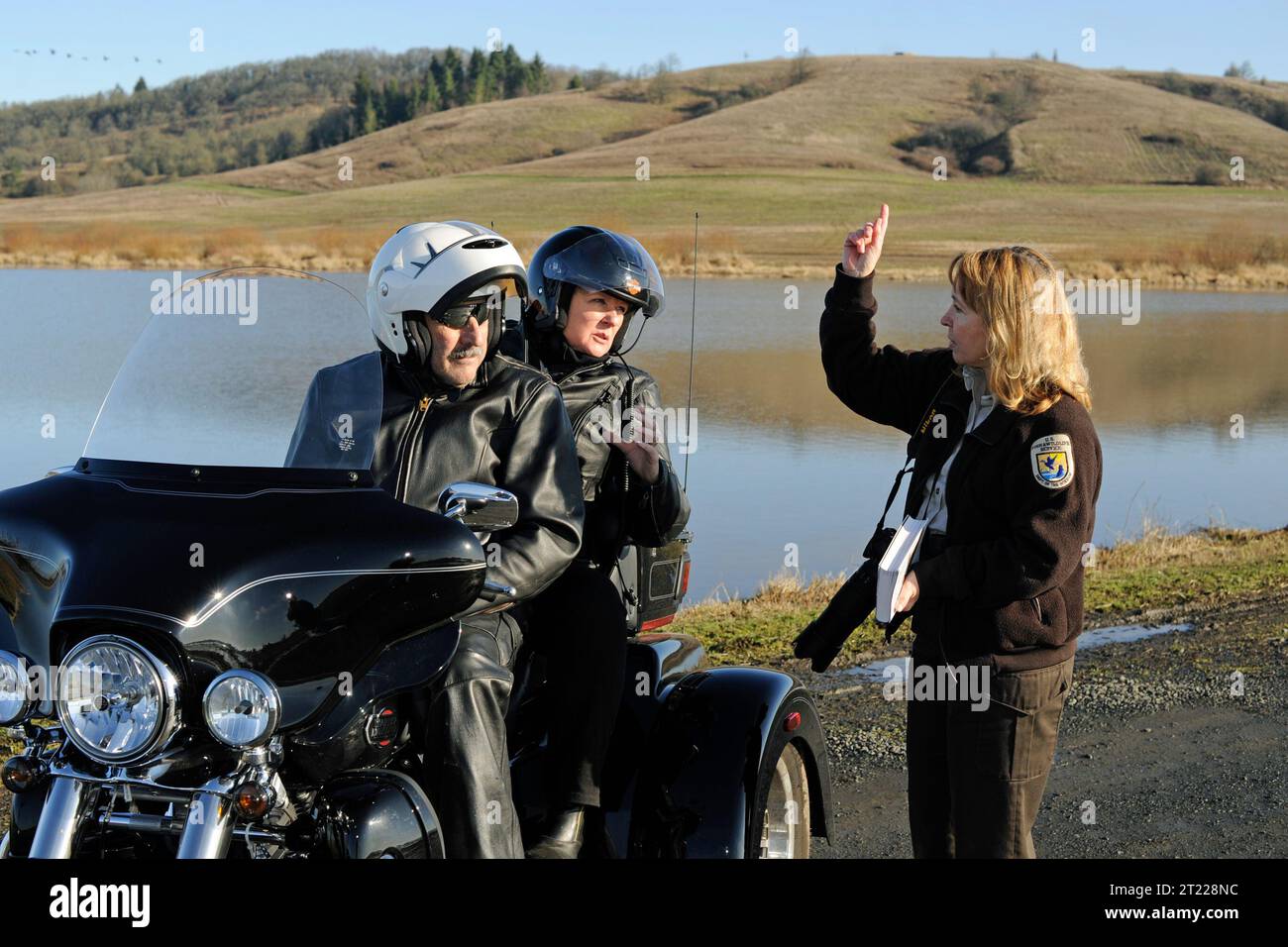 Un dipendente dello U.S. Fish and Wildlife Service parla con i visitatori in moto al William L. Finley National Wildlife Refuge in Oregon, rappresentando la sensibilizzazione del pubblico e il coinvolgimento dei visitatori. Foto Stock