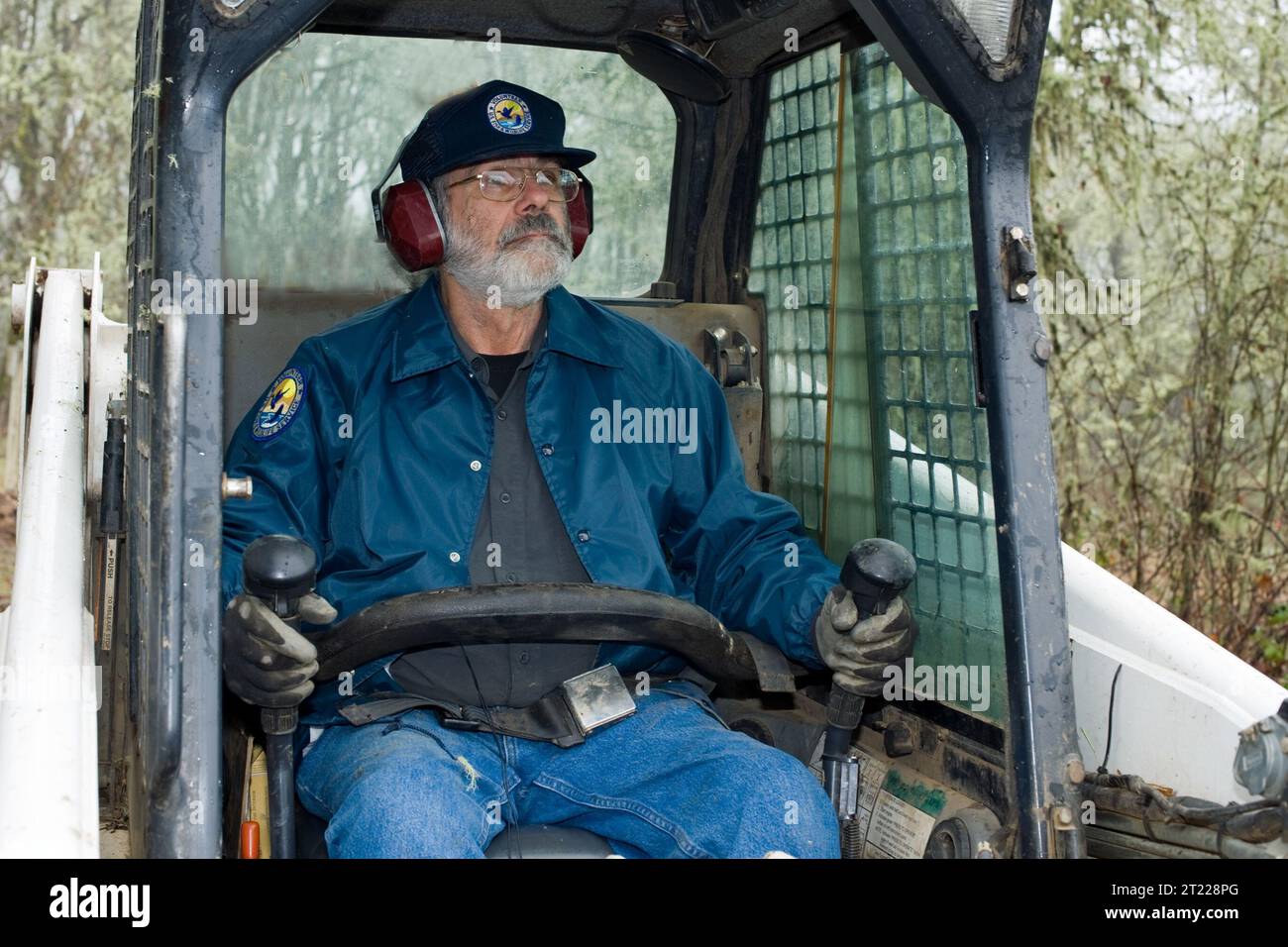 Un volontario gestisce una terna mantenendo i percorsi presso il William L. Finley National Wildlife Refuge in Oregon, sostenendo l'accesso all'habitat e gli sforzi di conservazione. Foto Stock