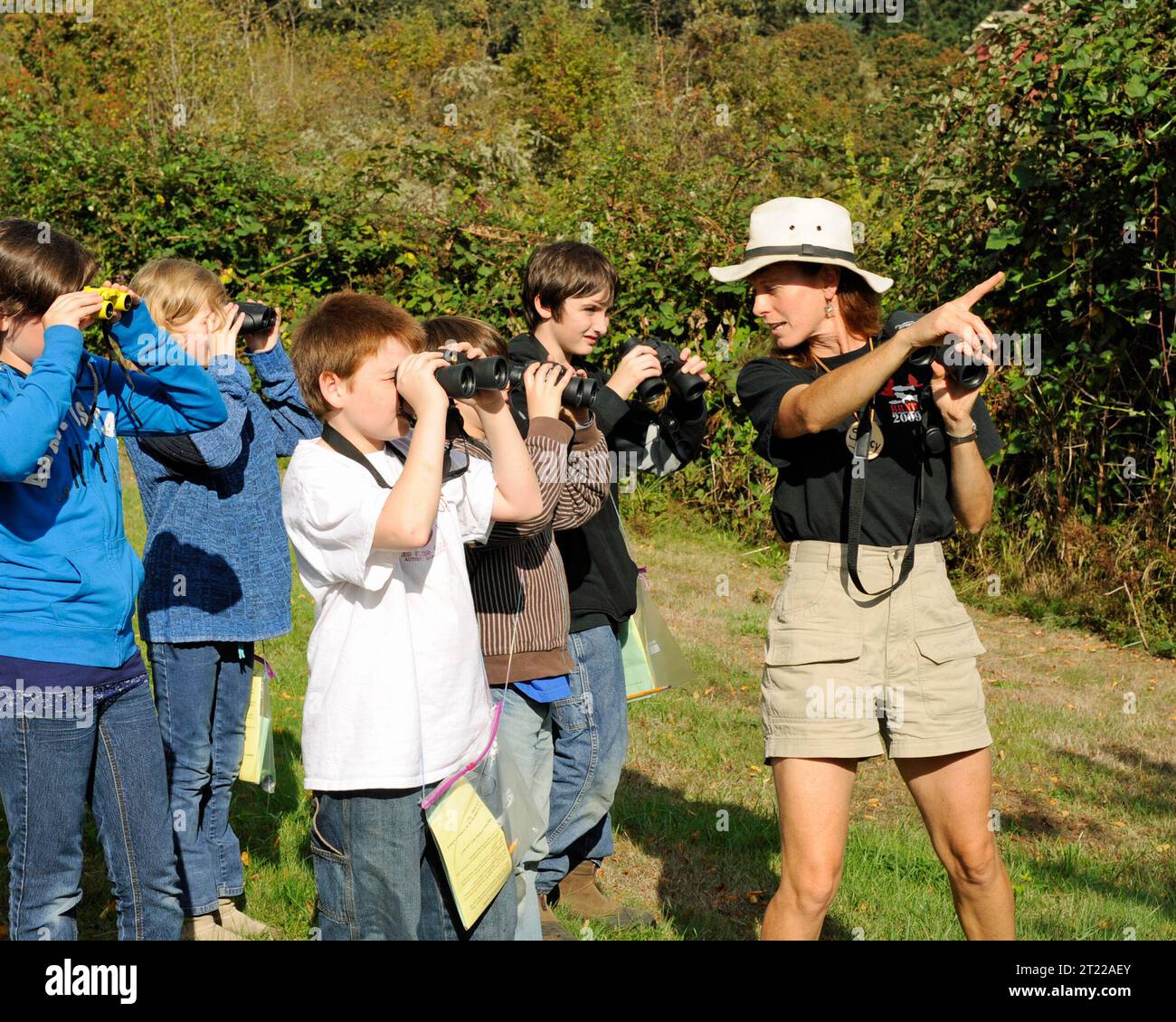 Gli studenti cercano gli uccelli usando un binocolo al William L. Finley National Wildlife Refuge, Oregon, come parte di un'attività di apprendimento basata sulla natura. Foto Stock