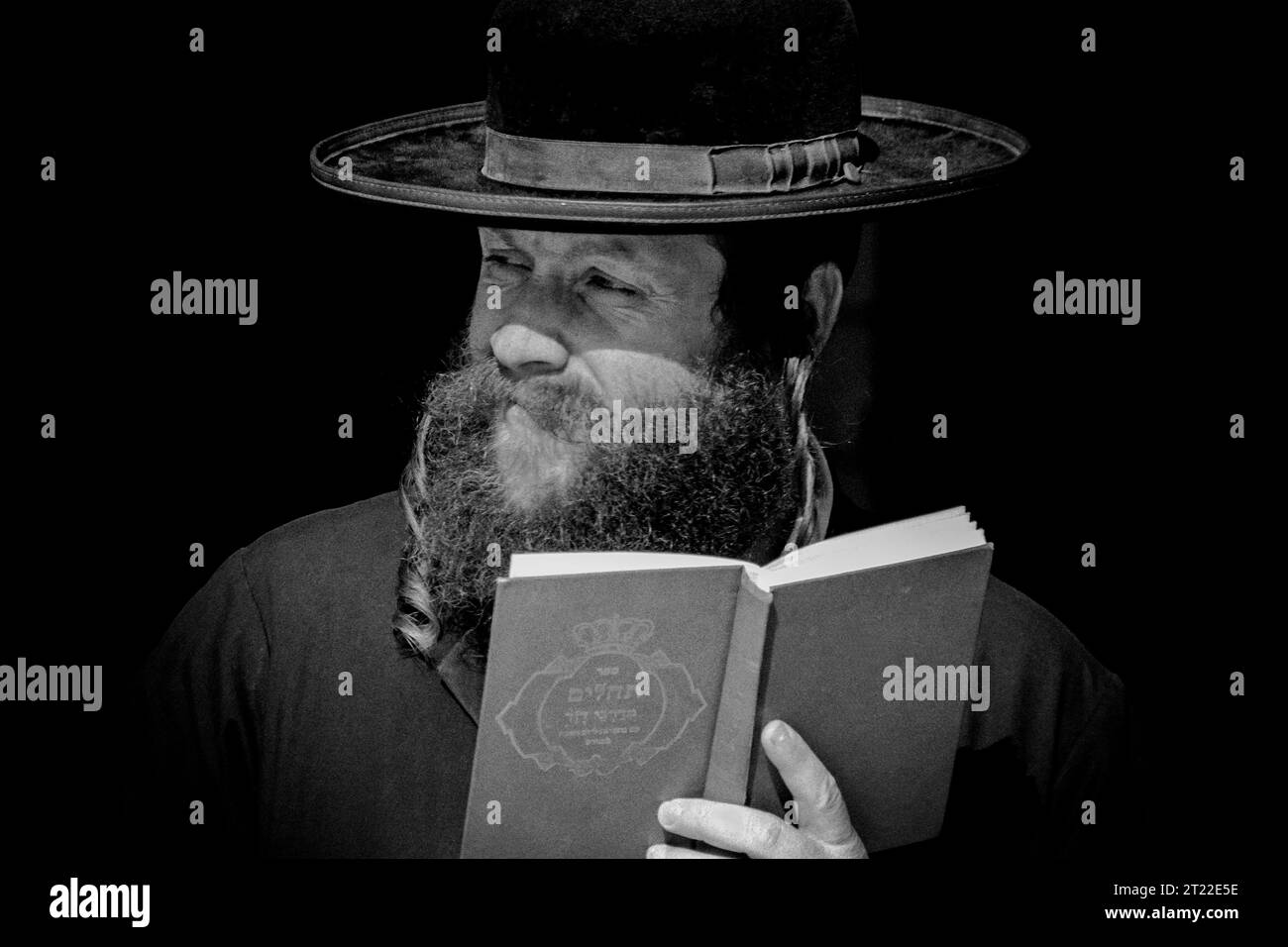 Israele, Gerusalemme: Rabbi con uno sguardo enigmatico legge la Torah sul muro del pianto Foto Stock