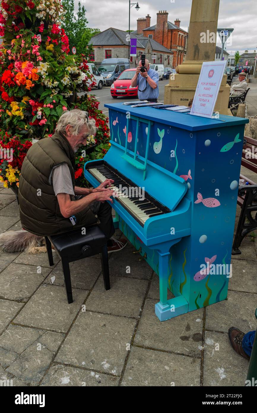 Carrick-on-Shannon, Leitrim Irlanda 12 luglio 2018 - Un uomo che suona un pianoforte blu per strada a Carrick on Shannon Foto Stock