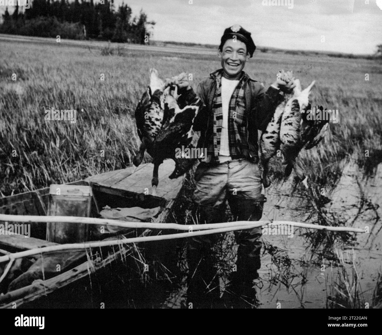 Un uomo si trova accanto a un battello, tenendo le oche che venivano cacciate come parte di un'attività di sussistenza in Alaska. La caccia, soprattutto da parte delle comunità native americane, è un mezzo tradizionale per ottenere cibo nelle aree rurali. Foto Stock