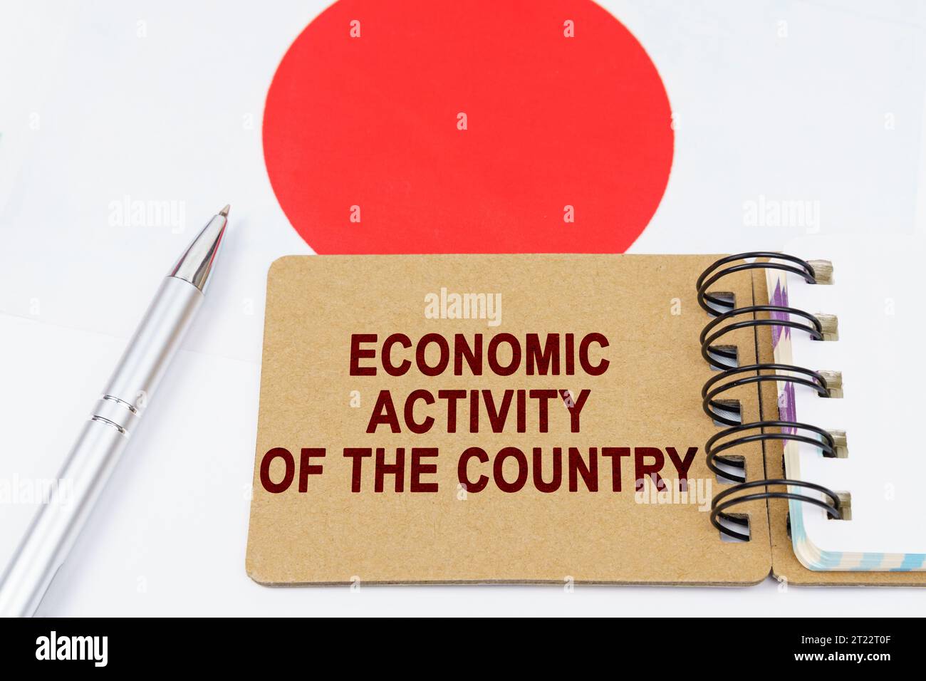 Economia e finanza. Sulla bandiera del Giappone si trova una penna e un quaderno con l'iscrizione - attività economica del paese. Foto Stock