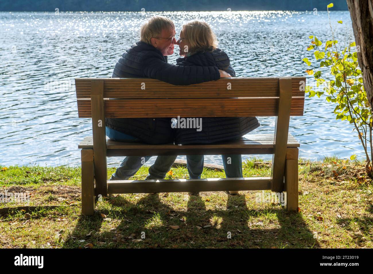 Liebe im Alter, Paar sitzt verliebt auf einer Bank am SEE, Moosach in Oberbayern, Oktober 2023 Deutschland, Moosach, Oberbayern, 16) Oktober 2023, Liebe im alter, Paar sitzt auf einer Bank am SEE und kommt sich näher, Mann und Frau haben sich verliebt, schauen sich in die Augen, romantisch, Symbolfoto, Partnersuche im alter, Herbst des Lebens, Mann trifft Frau, beide Ü60, Rentner, Senioren, kennenlernen, treffen, Bayern *** amore in vecchiaia, coppia seduta innamorata su una panchina sul lago, Moosach in alta Baviera, ottobre 2023 Germania, Moosach, alta Baviera, ottobre 16, 2023, amore in vecchiaia, c Foto Stock