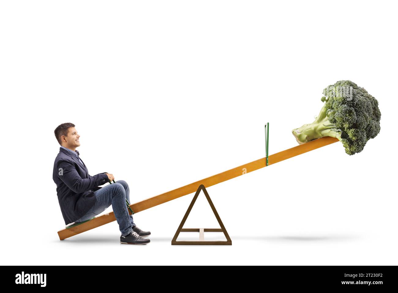 Foto profilo completo di un giovane uomo e broccoli vegetale su una seesaw, concetto di dieta sana isolato su sfondo bianco Foto Stock