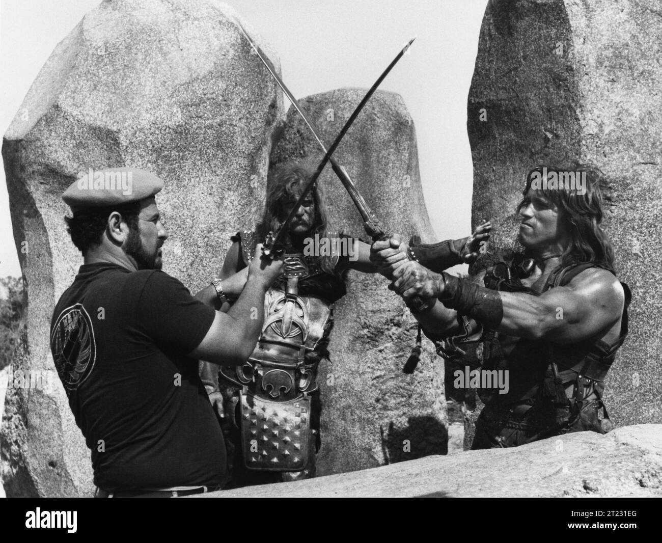 Il regista JOHN MILIUS BEN DAVIDSON e ARNOLD SCHWARZENEGGER sul set di CONAN IL BARBARO personaggio del 1982 creato da ROBERT e> HOWARD Costume Design JOHN BLOOMFIELD Music BASIL POLEDOURIS Universal Pictures Foto Stock