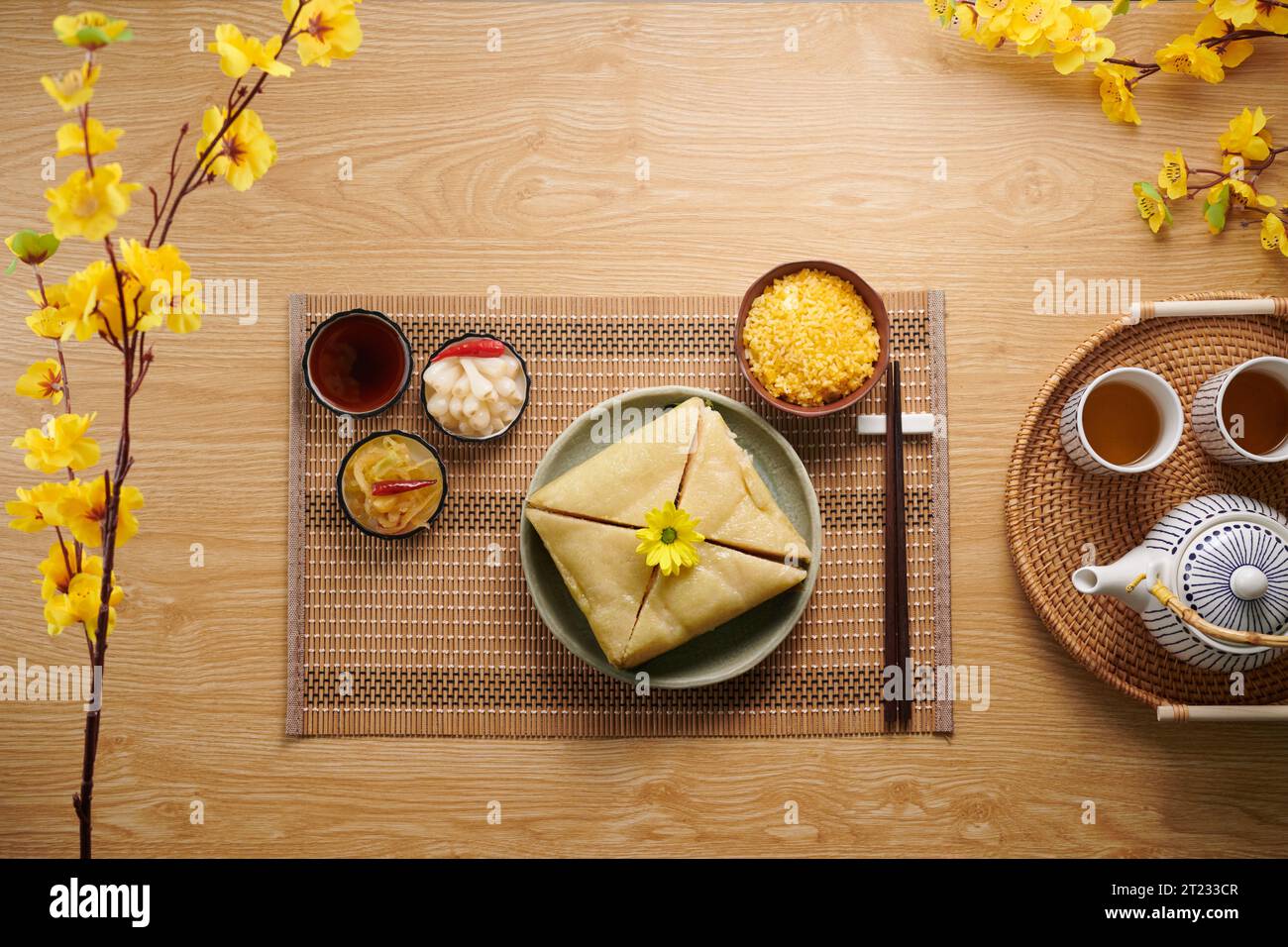 Tradizionale torta di riso quadrata vietnamita e altre prelibatezze per gli ospiti della cena Tet Foto Stock